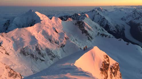  Gleichzeitiges Gehen am Seil | Überarbeitete deutsche Version (in German) - A breathtaking aerial view of snow-capped mountain peaks bathed in the warm glow of the setting sun, creating a stunning contrast against the cool, blue hues of the sky. 1