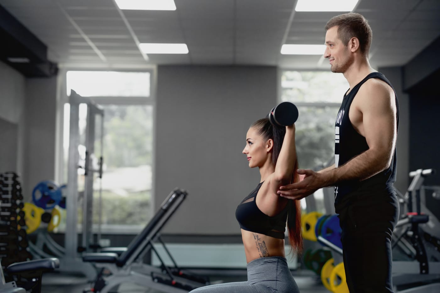 Coach demonstrating lifting technique to an athlete