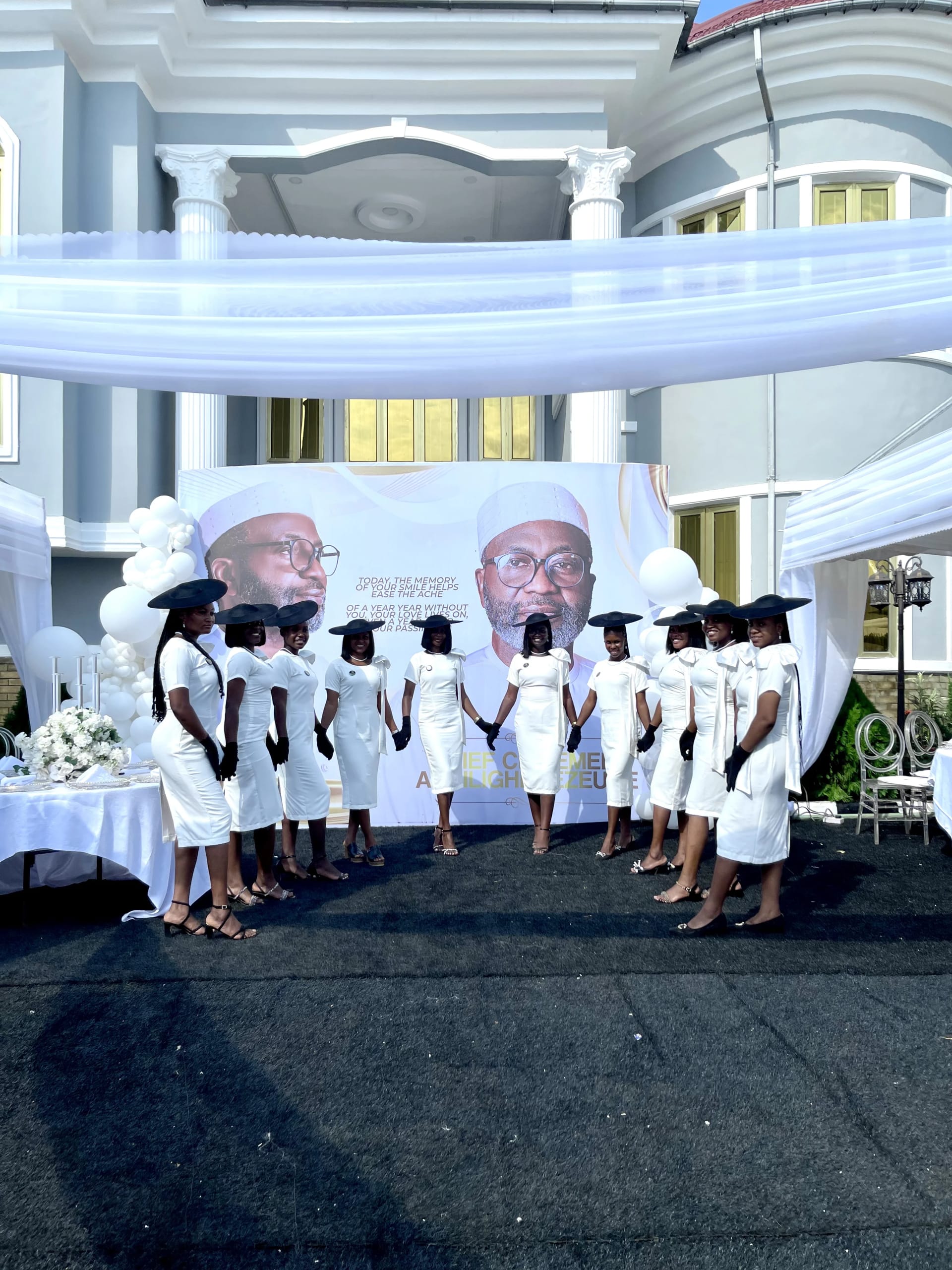 Large team in all-white at outdoor tribute event