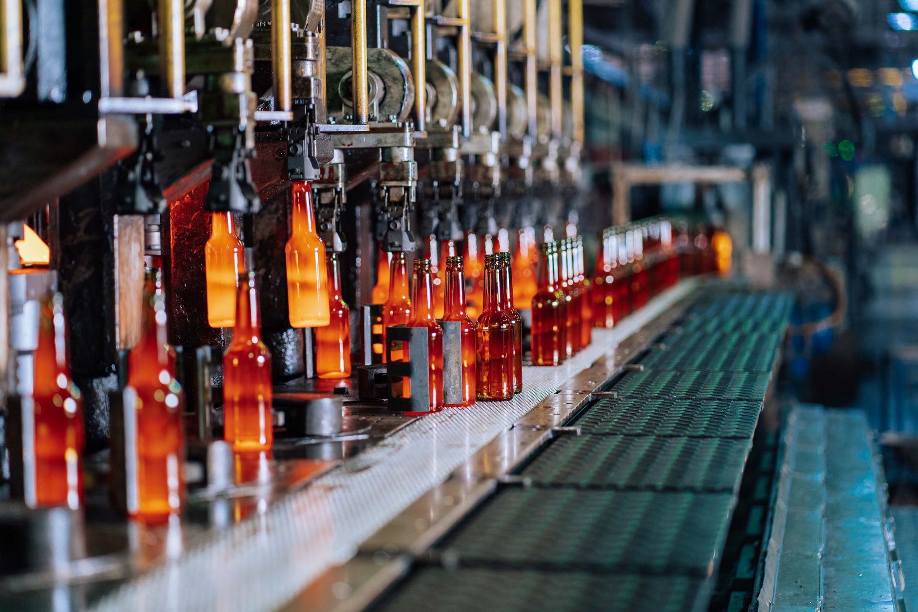 Glass bottles being manufactured on an automated production line in a factory.
