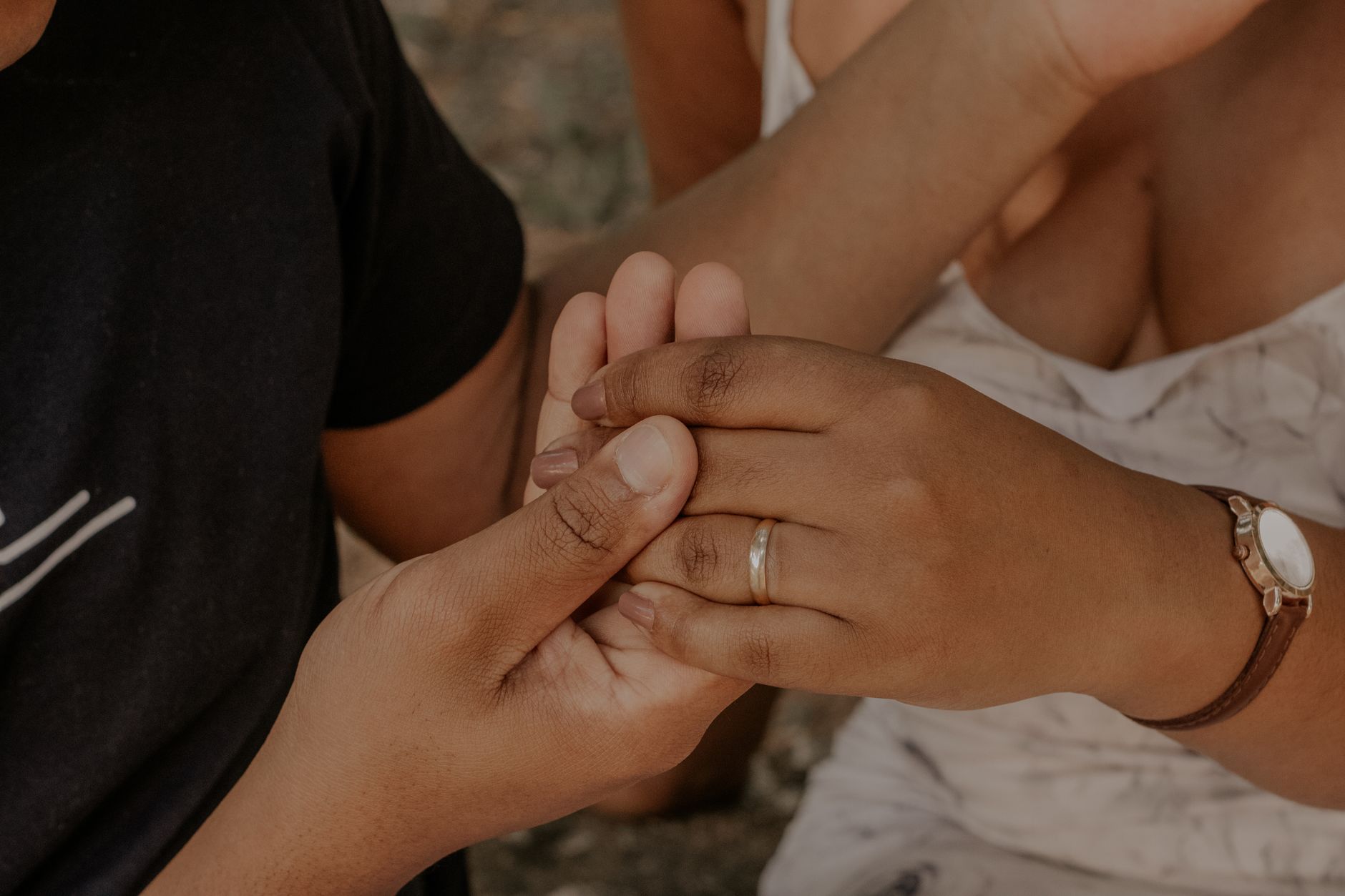 Intimate moment of couple's hands holding each other, showing love and warmth.
