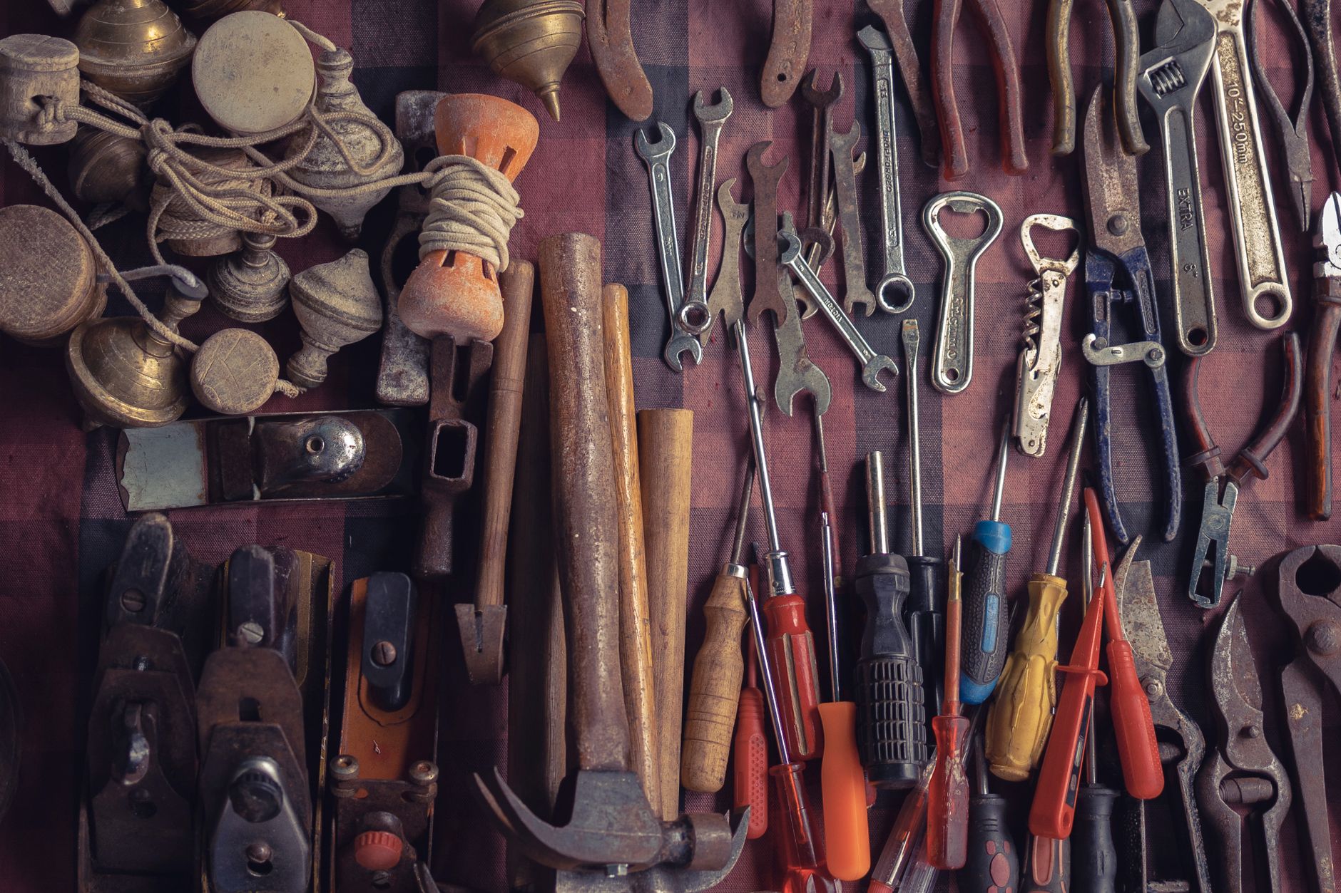 Collection of vintage tools arranged in a flat lay in a workshop setting.