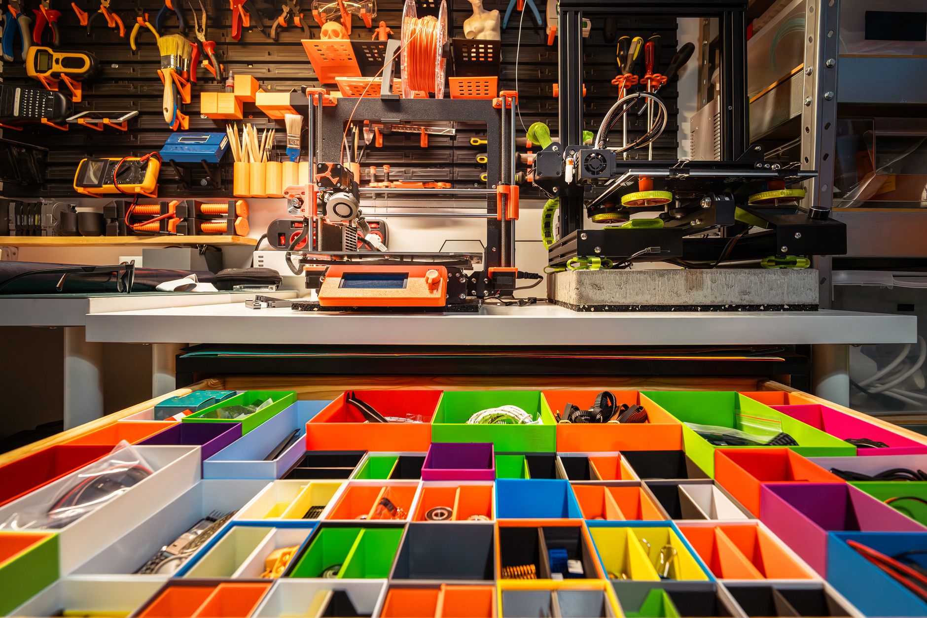 Vibrant workshop scene featuring a 3D printer, organized tools, and colorful storage containers.