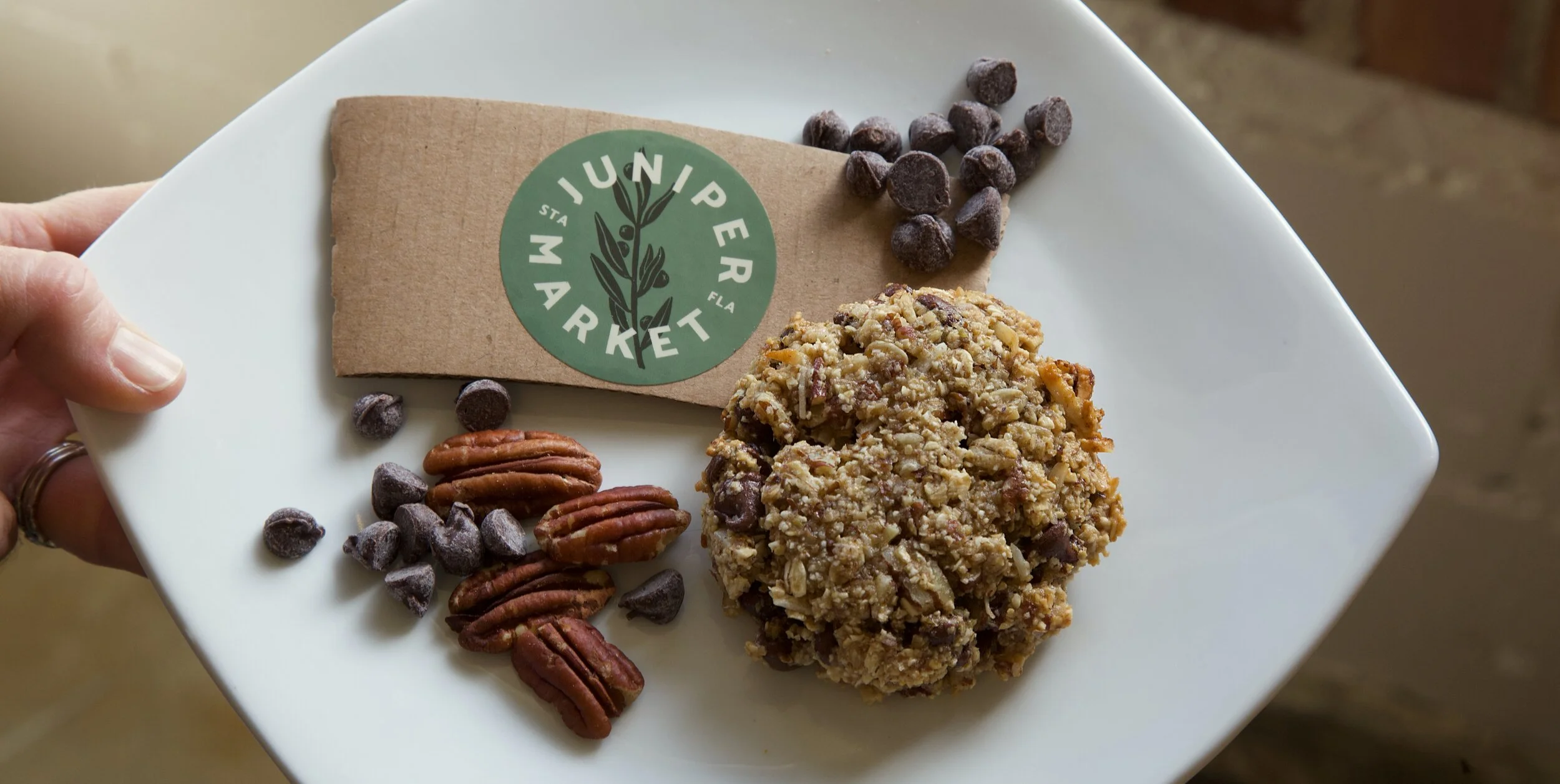 A Juniper Market cookie plated with pecans and chocolate chips