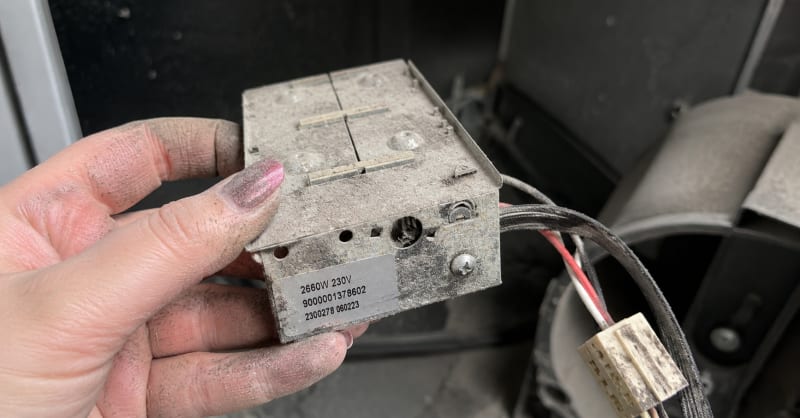 Pelusa acumulada en la resistencia calefactora de la secadora — causa de olor a quemado