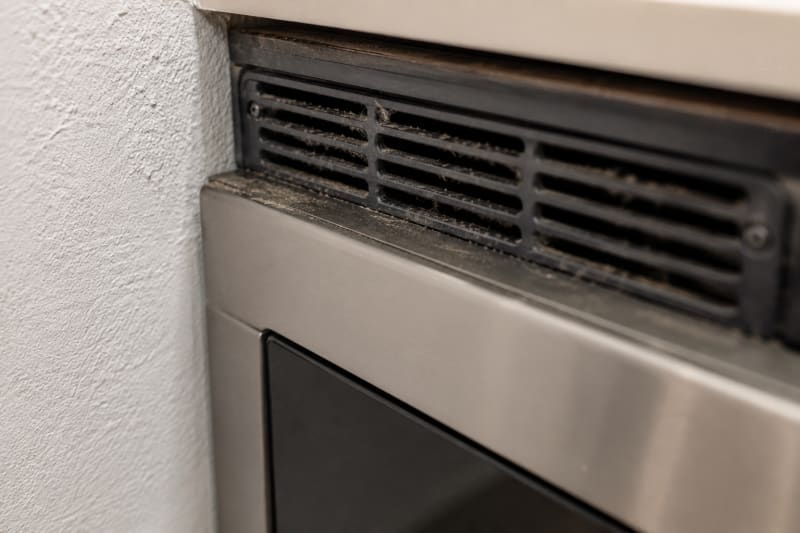 Rejilla de ventilacion del microondas obstruida y pegada a la pared