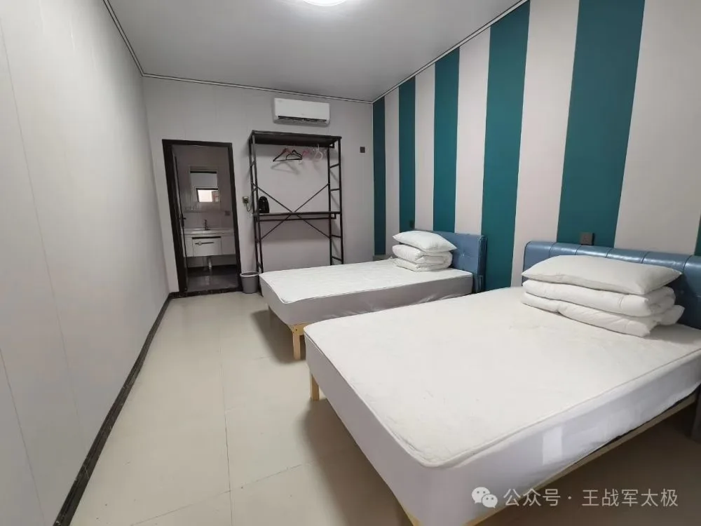 Twin student dorm room with blue and white wallpaper