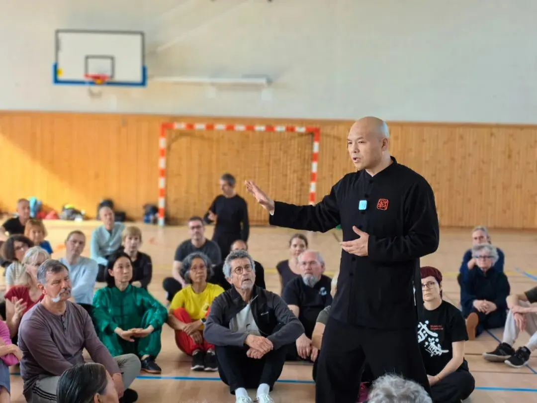 Instructor explaining Tai Chi in indoor gym