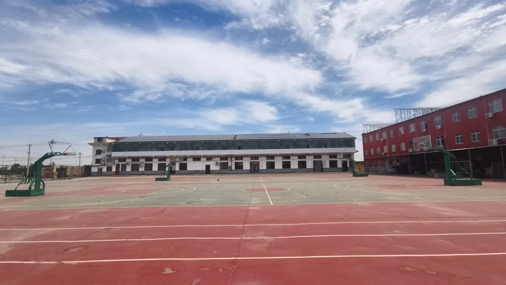 Outdoor sports court with red track and green basketball court