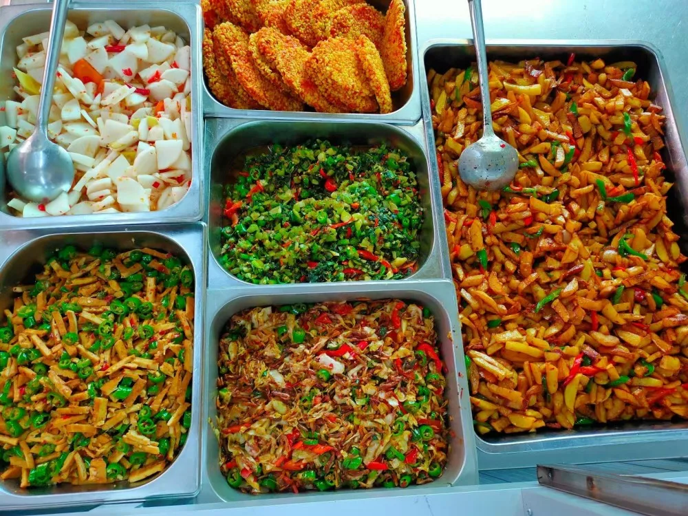 Food display with various dishes in stainless steel trays