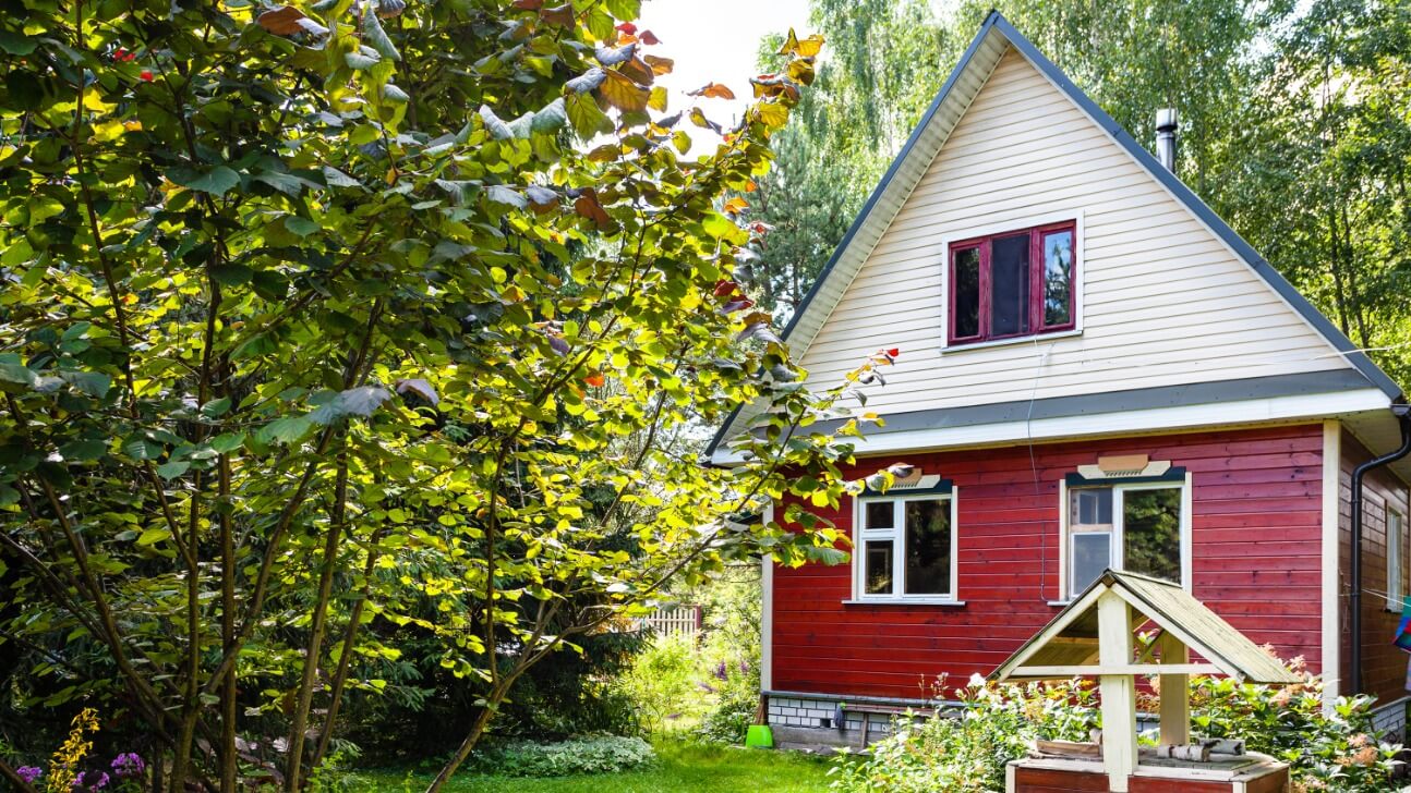 small wooden country house and well on backyard