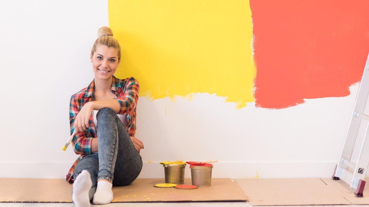 young female painter sitting on floor