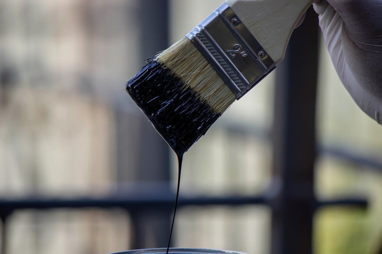 close up of a hand painting a metal pipe