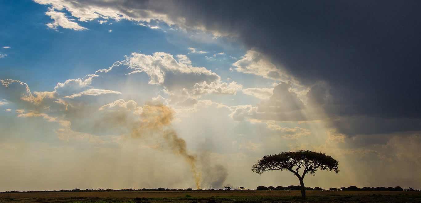 Rainclouds, fire over Zambian landscape