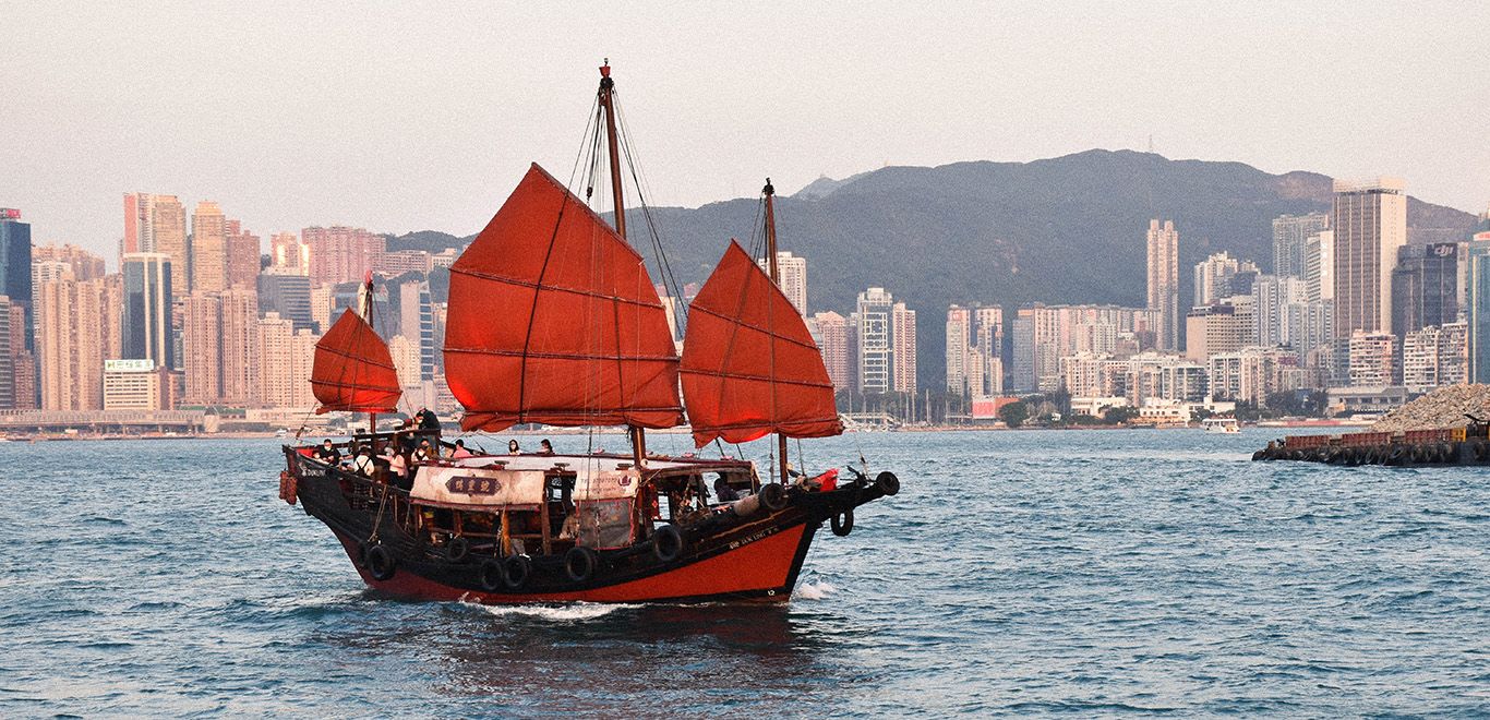 A red junk boat sailing in the sea in Hong Kong