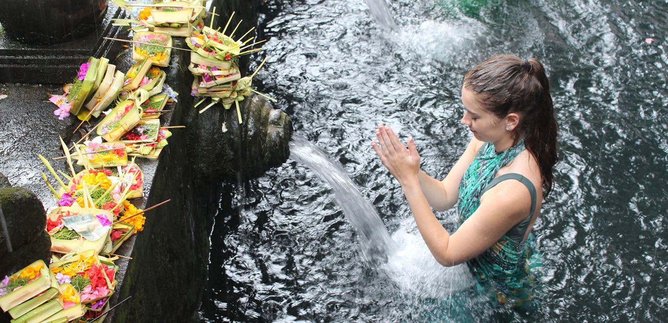 Girl praying at the holy water