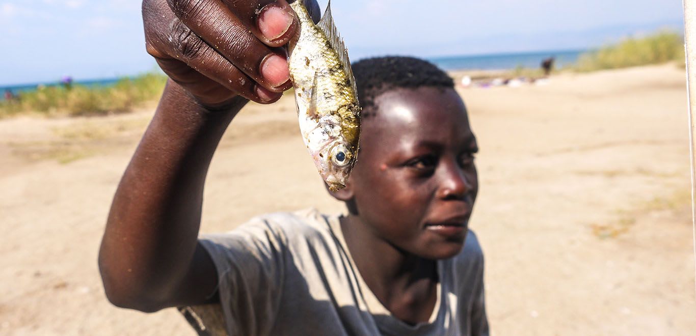 Boy holding a fish in Malawi