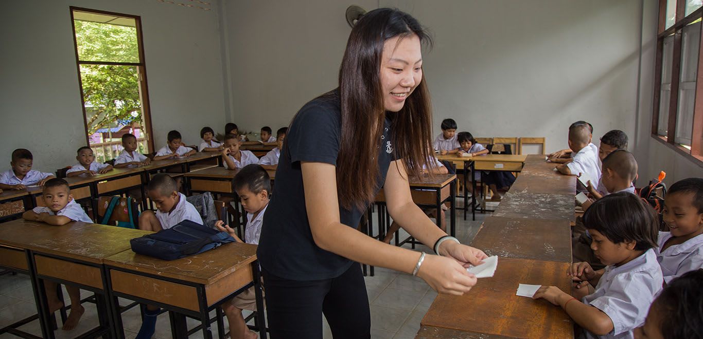 Teacher handing out assignment in Thailand