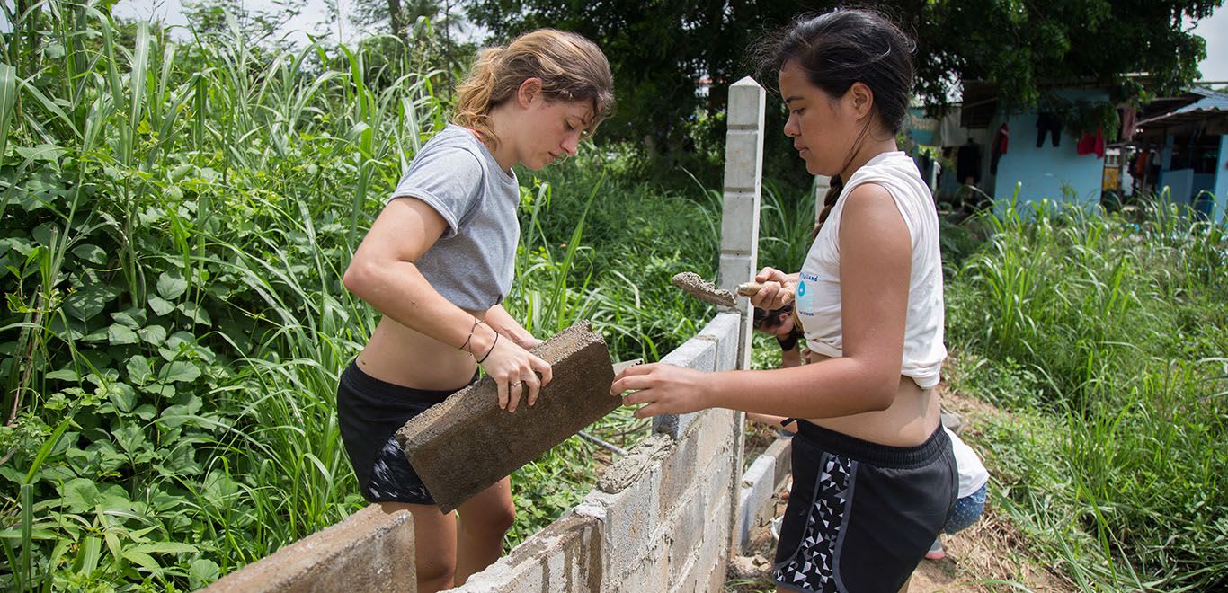 Two women building a wall in Thailand