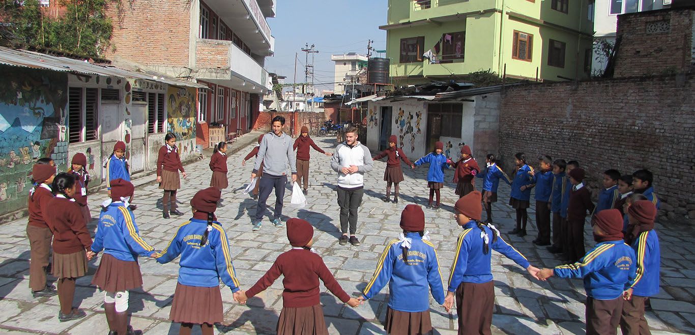 Volunteers in the playground with kids