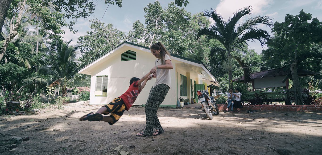 Teacher swinging child in Palawan, Philippines