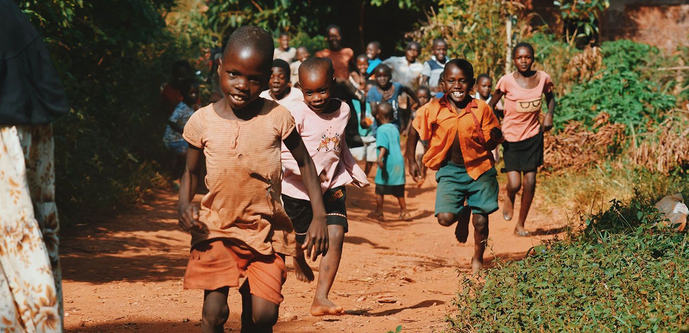 Kids running in a village in Uganda