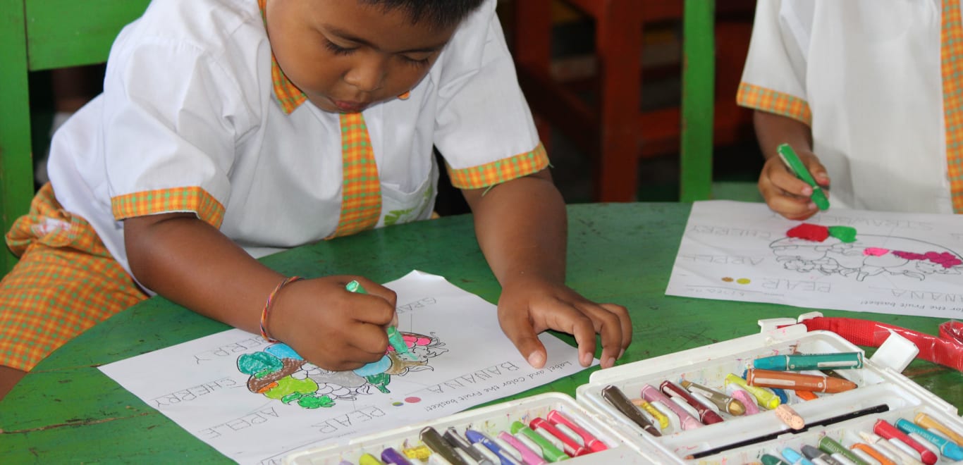 Child coloring in class in Bali