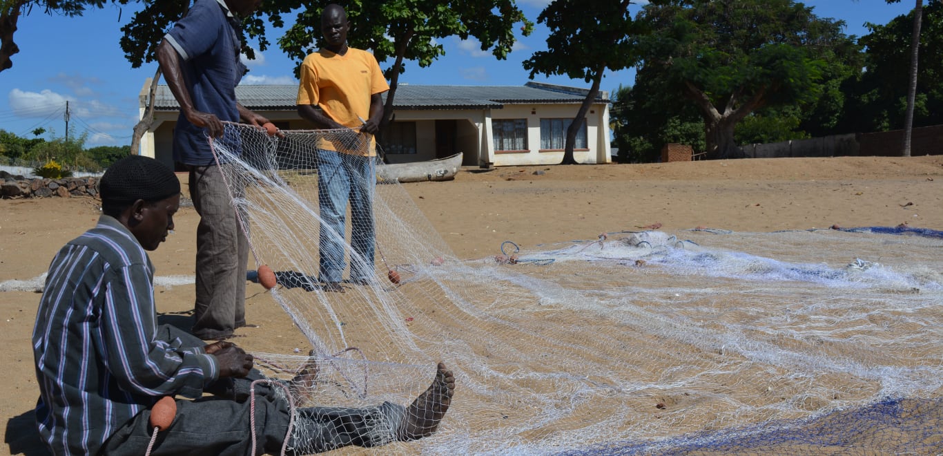 Men preparing a fishing net in Malawi