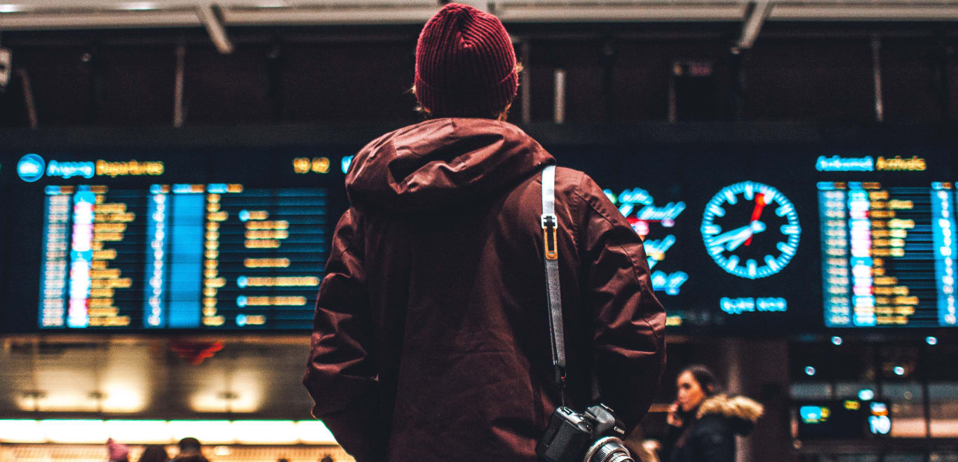 Traveler at an airport looking at the flight status board