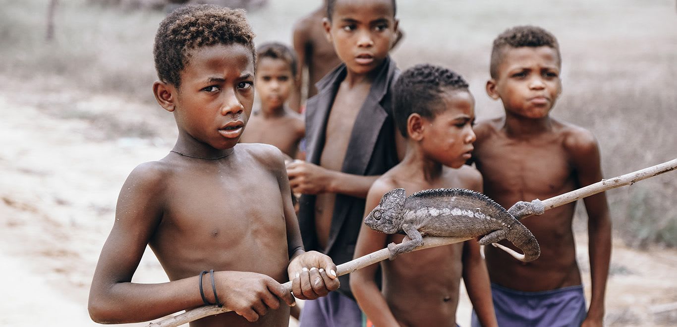 Kids in Antananarivo, Madagascar playing with a lizard