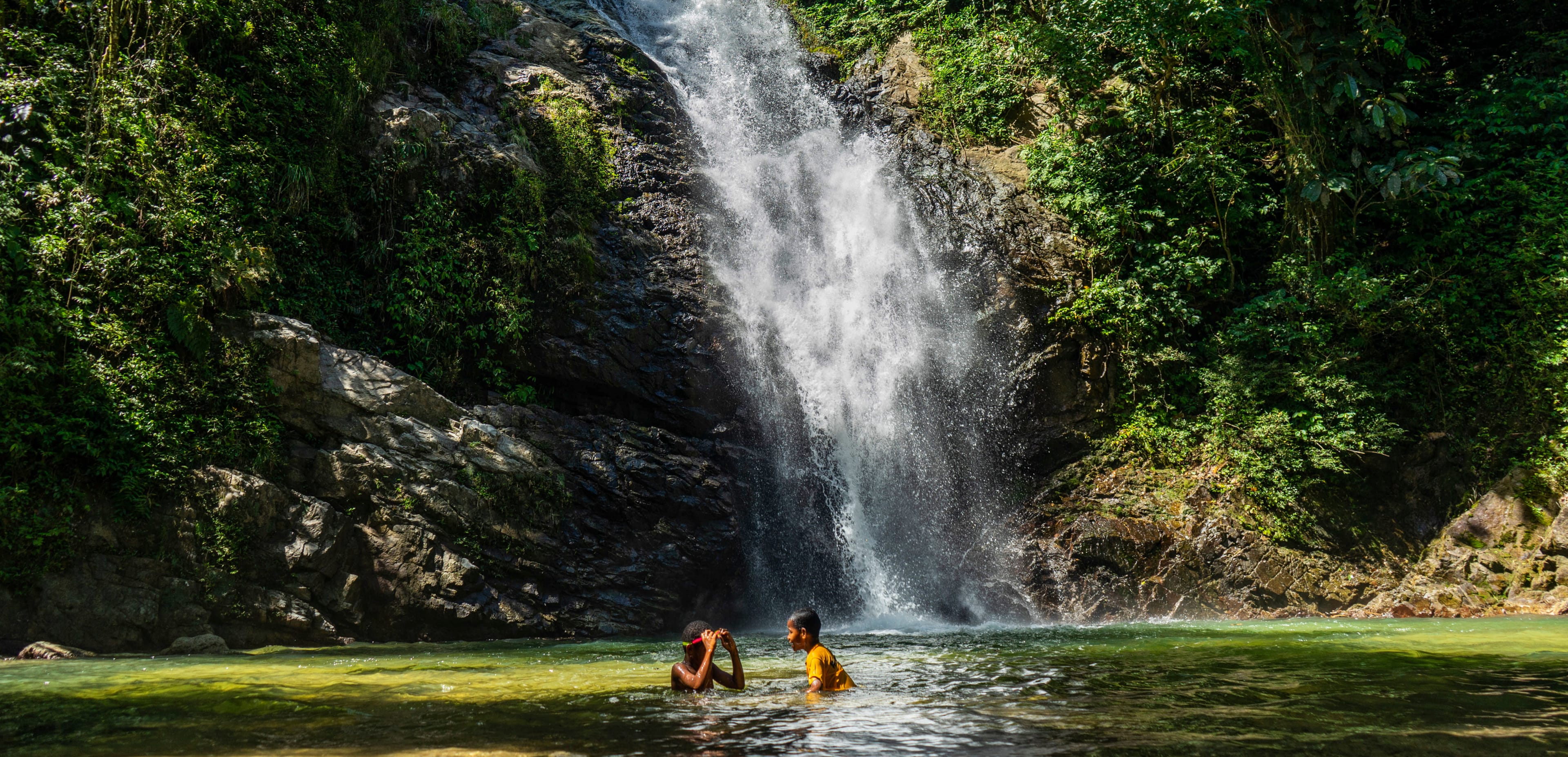 Kids playing at a waterfall in Fiji