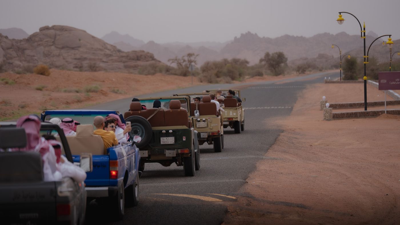 Open-top vintage Land Cruiser convoy through Jubbah