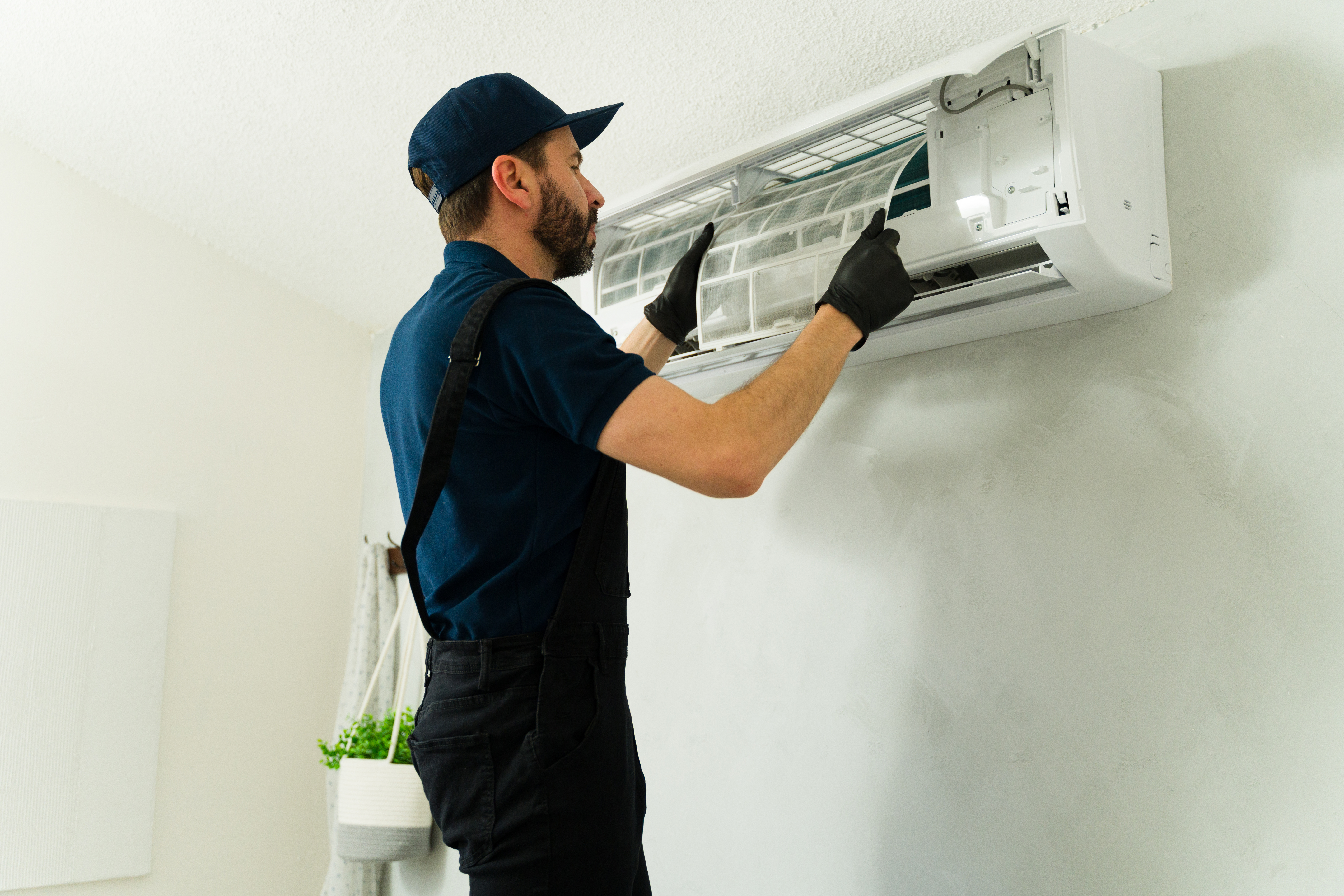 Technician looking at circuit board of HVAC unit