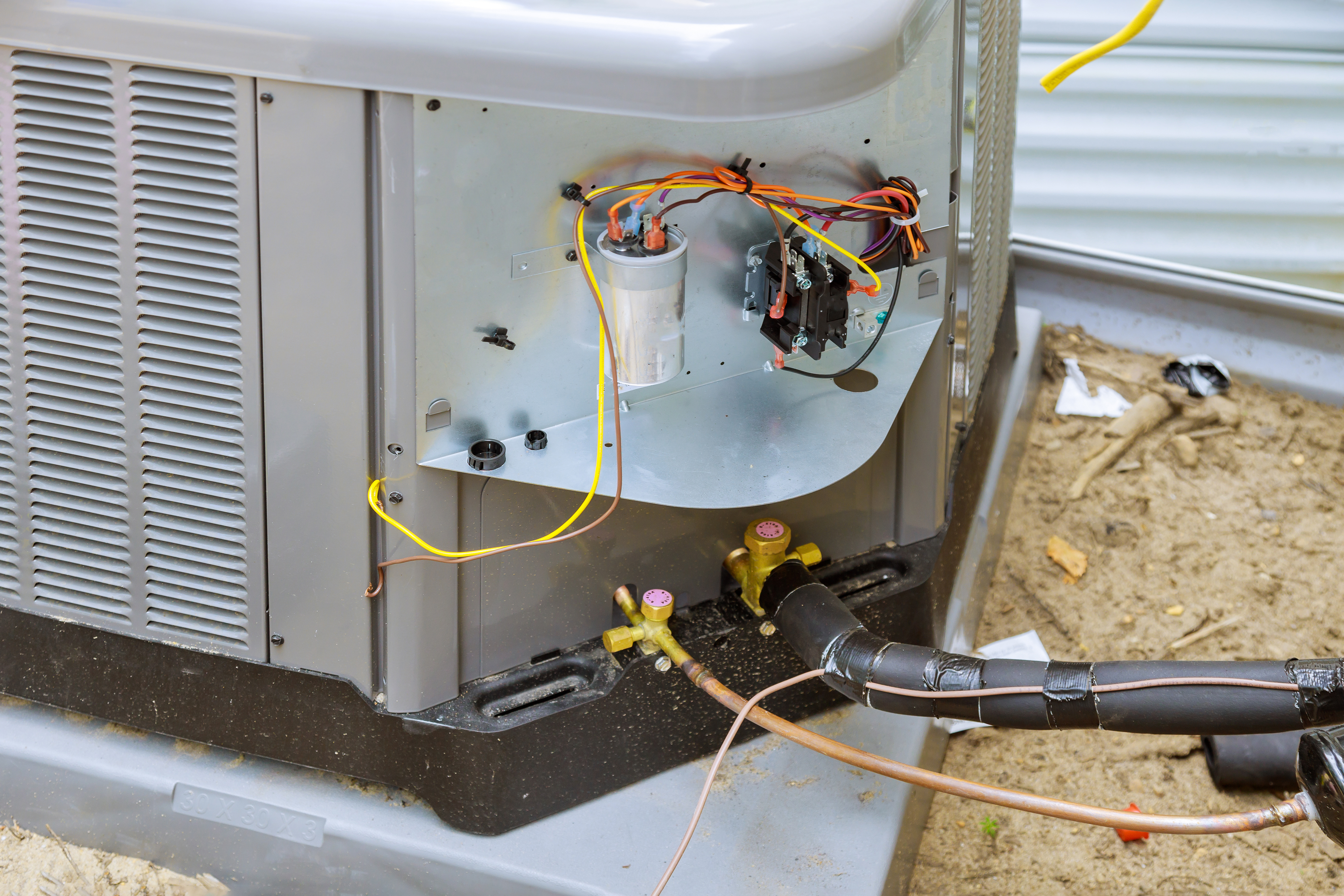 Technician working on AC unit at night showing emergency response