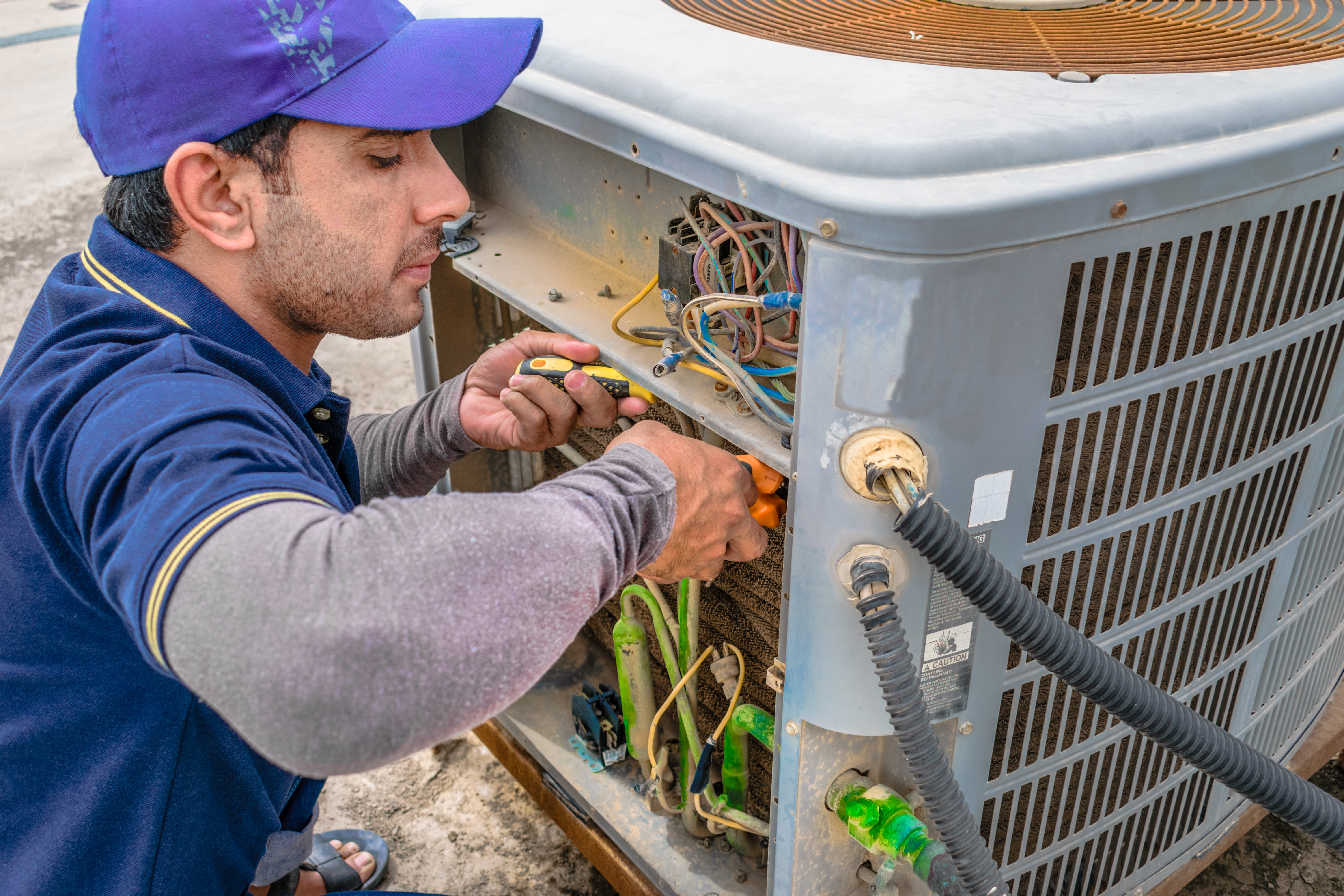 AC technician repairing air conditioner in Miramar home