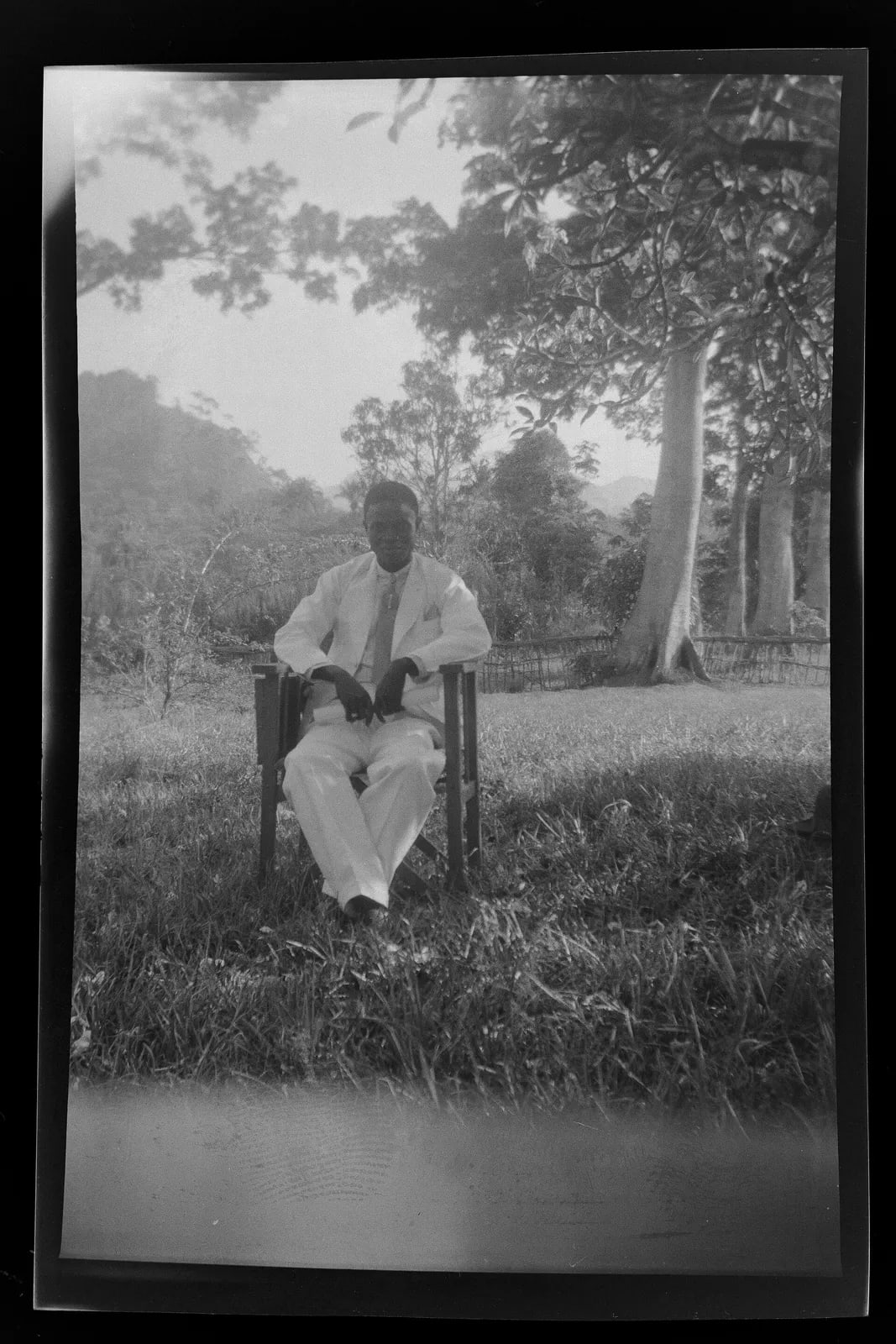 Man sitting in the backyard of the guesthouse, Panguma