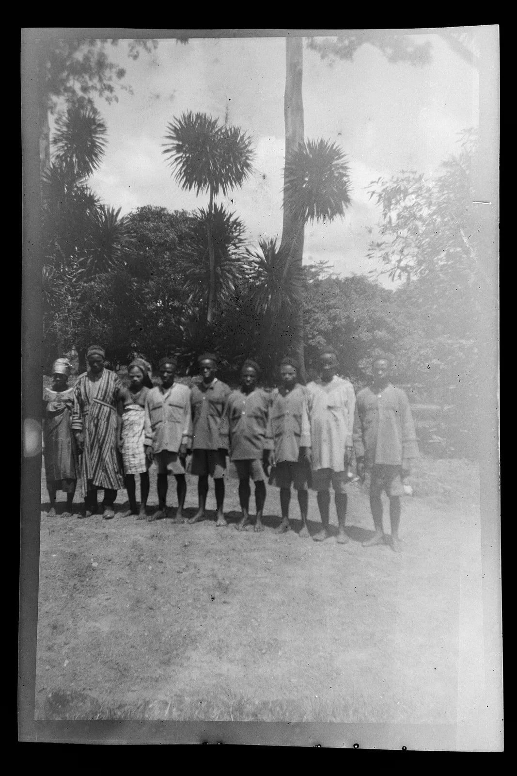 Women and men standing in a line in the yard of the guest house