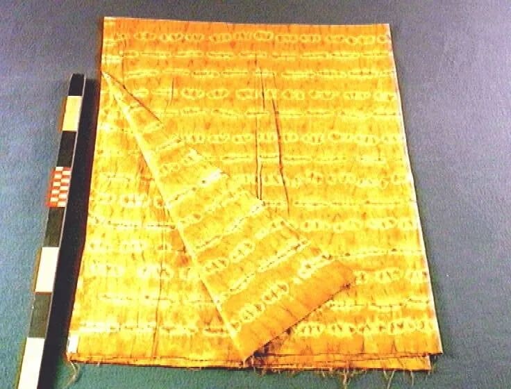 Rust-brown gara cloth with rows of tied marks