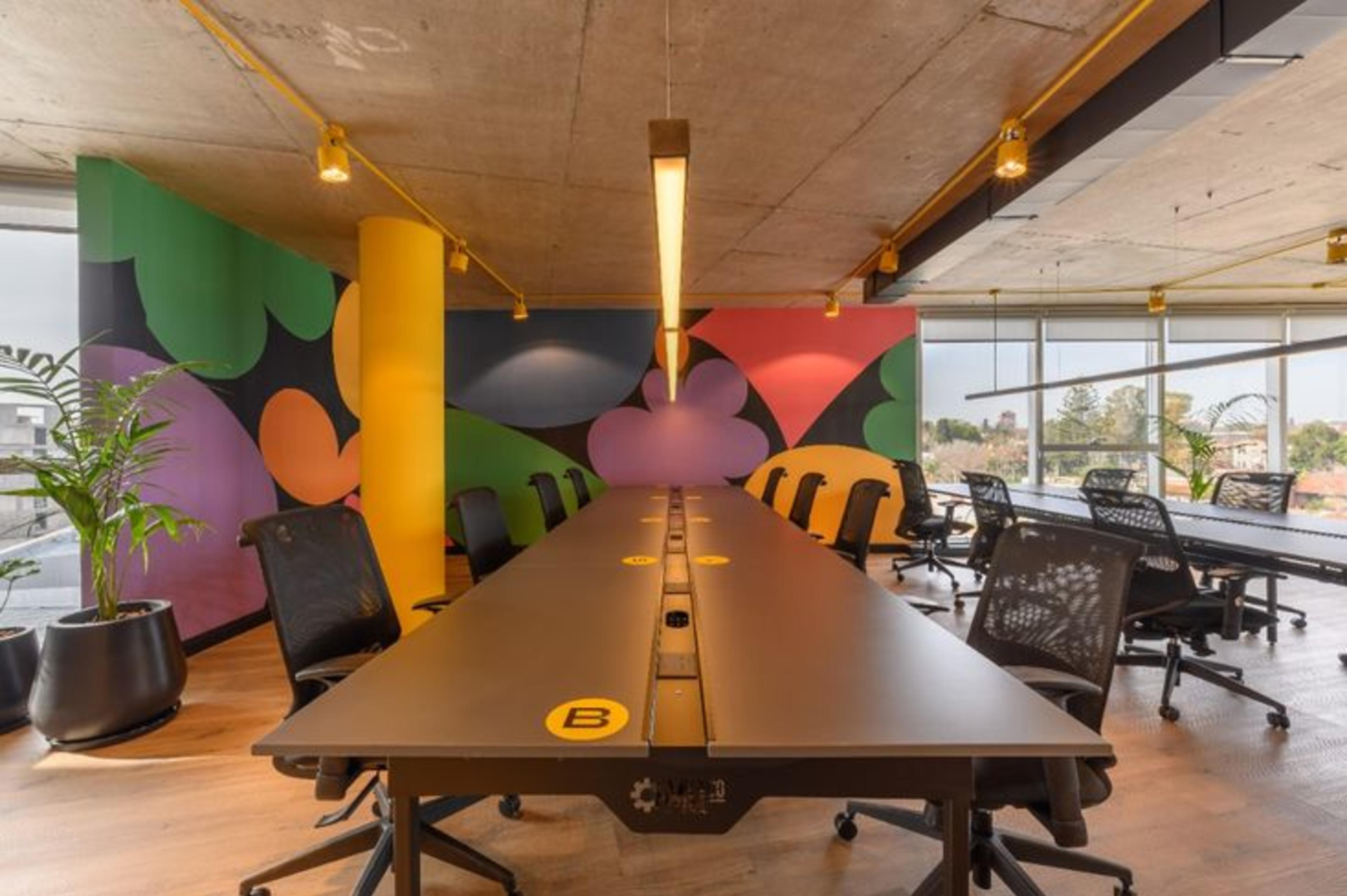 Coworking Space in Bangalore featuring black chairs black desks and creative wall artwork in a modern office setting