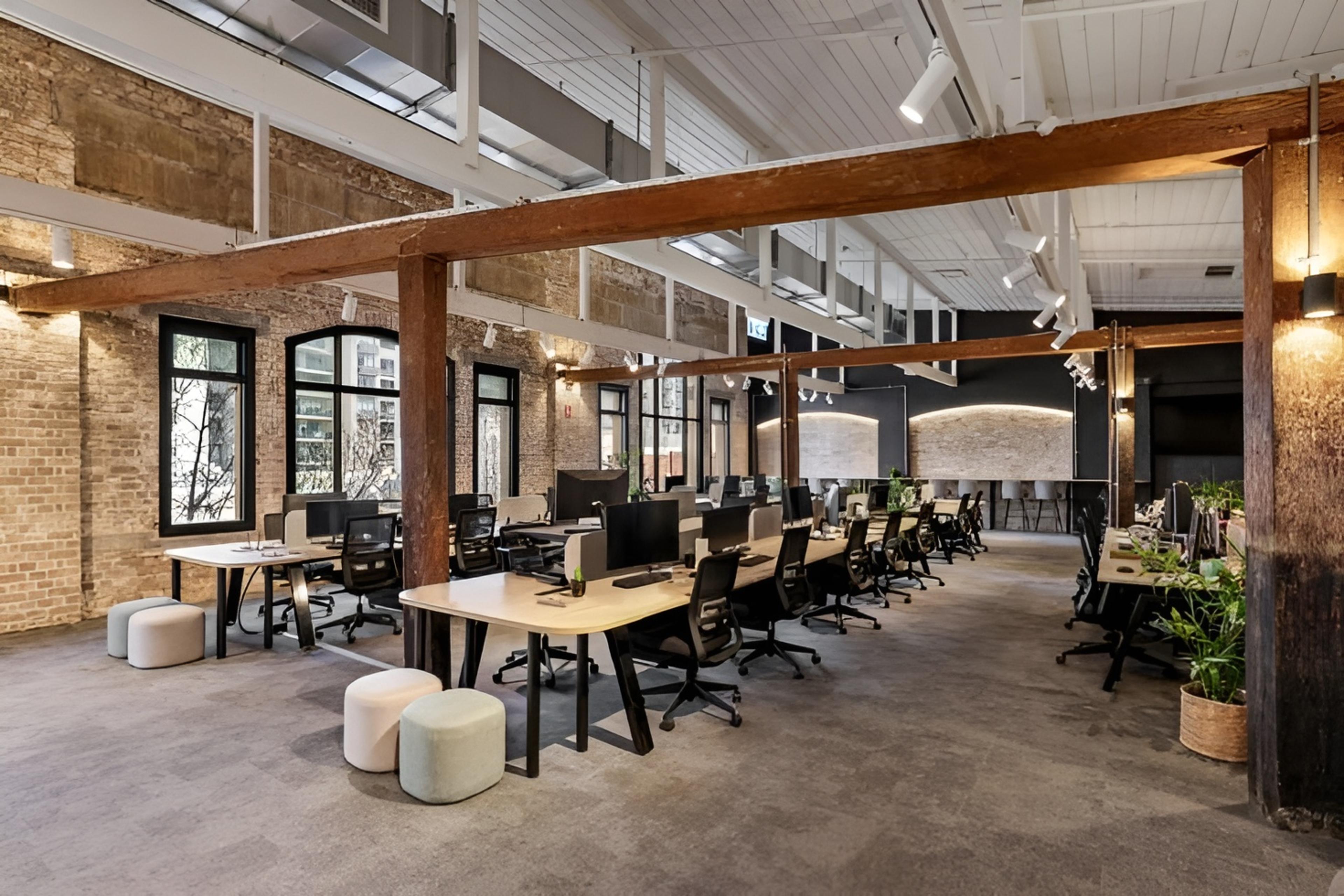Hot desks in HSR Layout with black monitors placed on biscuit colour desks in a bright and professional office workspace