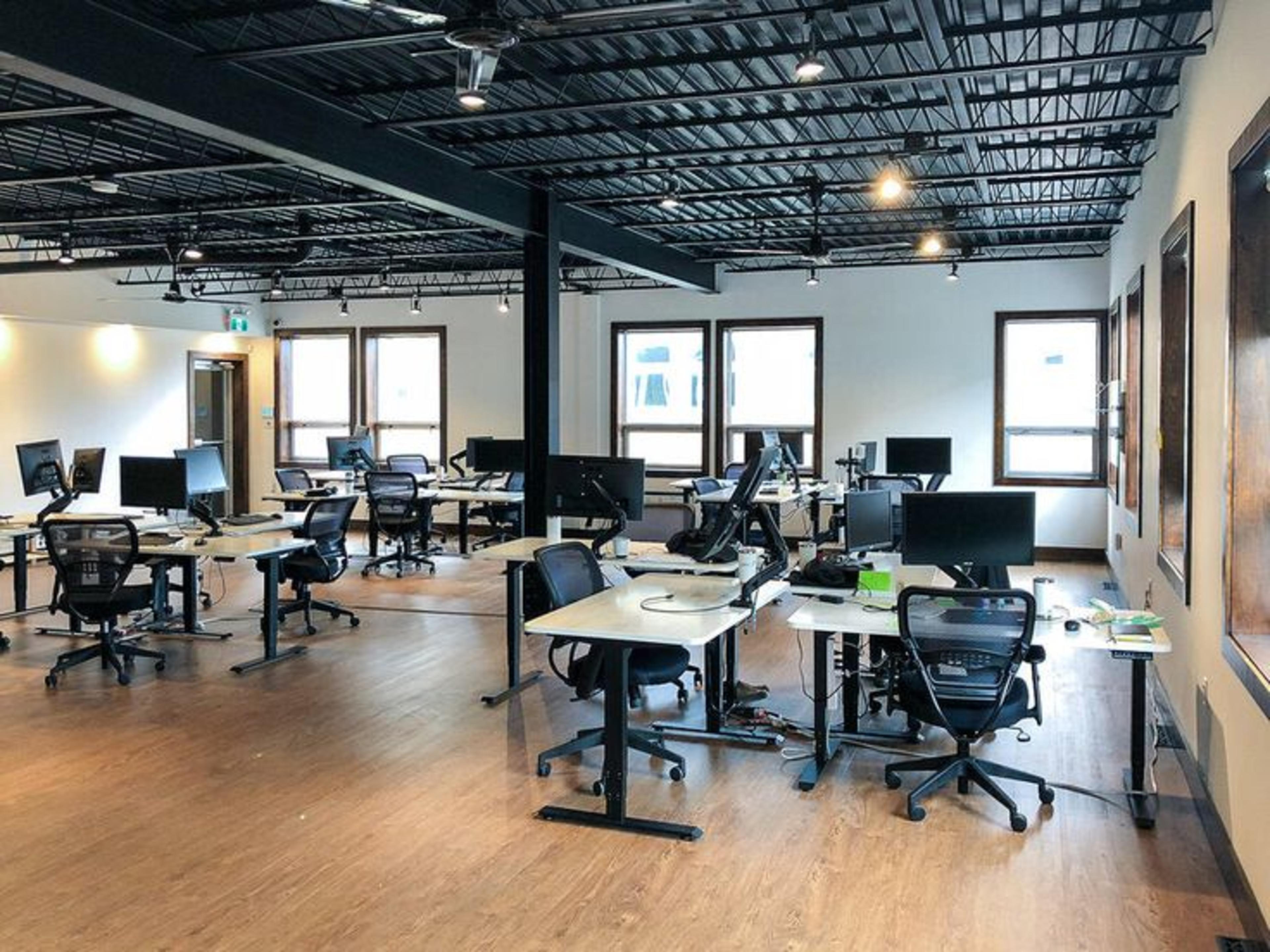 Private Cabin Coworking Space in HSR Layout with black chairs and white desks arranged in four rows under black ceiling with ambient lighting