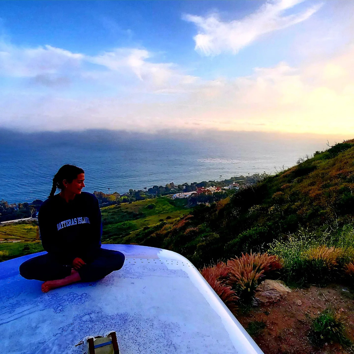 Melissa Jernigan Sitting on Skoolie Roof Overlooking Pacific Ocean