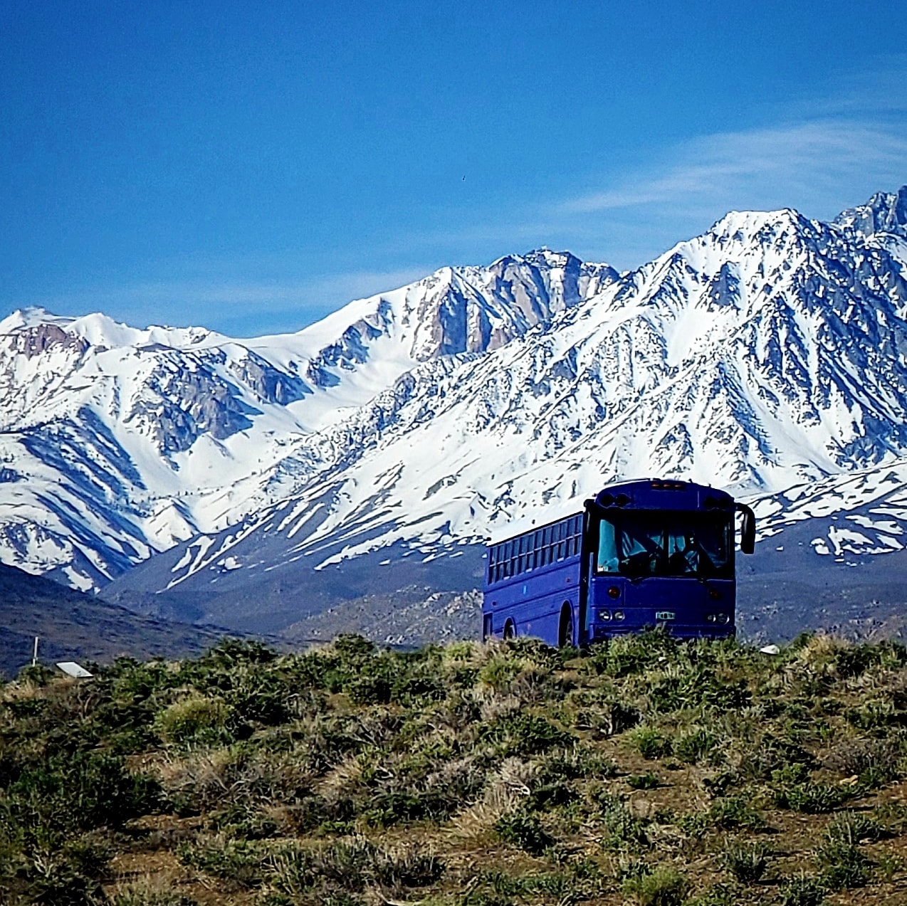 Skoolie in Front of Snowcapped Mountains