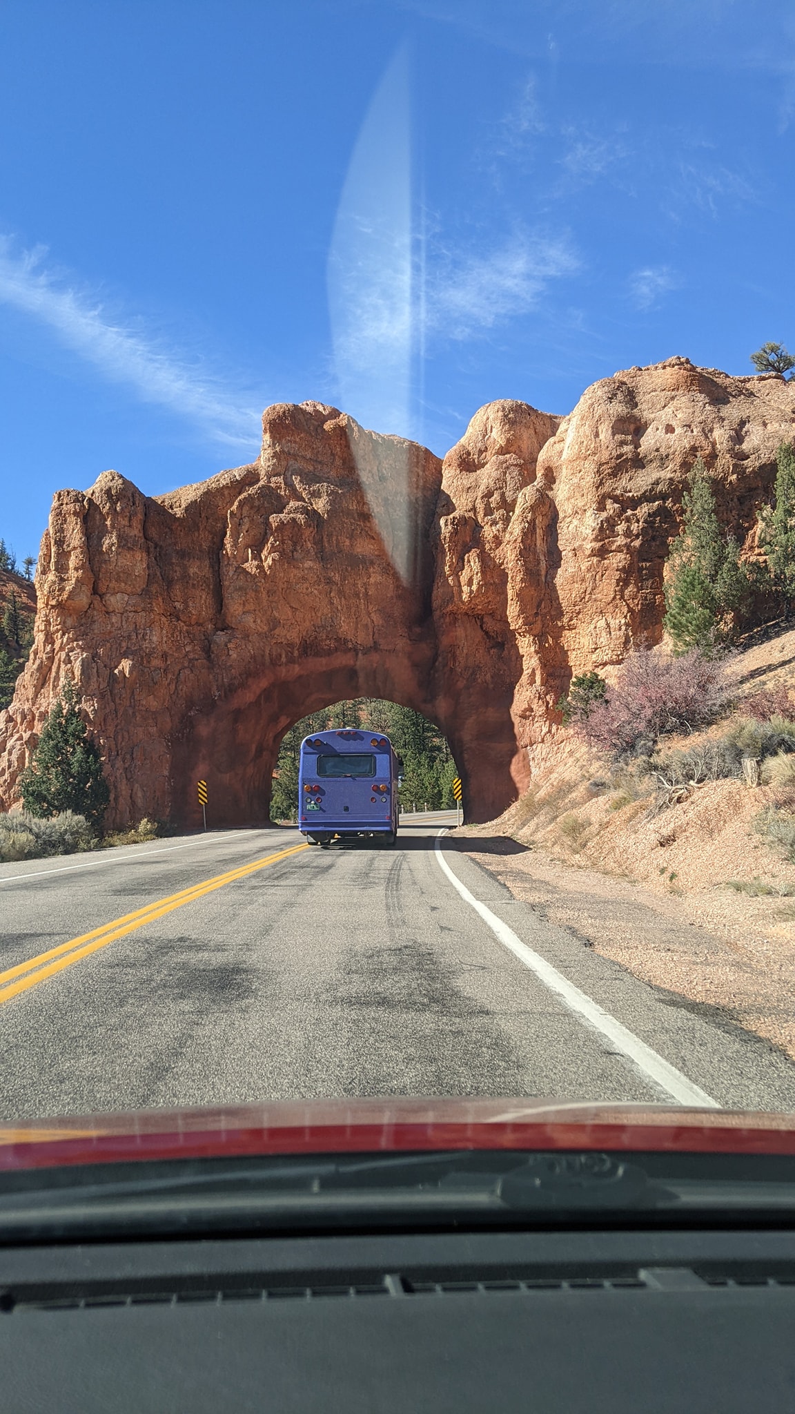Skoolie Driving Under Arch in Utah