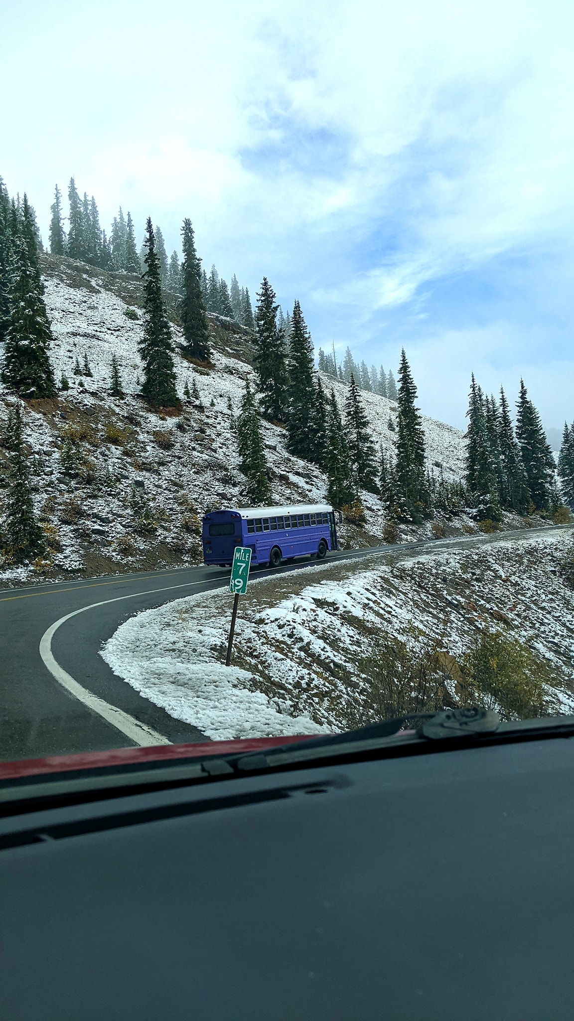 Skoolie Going Up Snowy Mountain Pass
