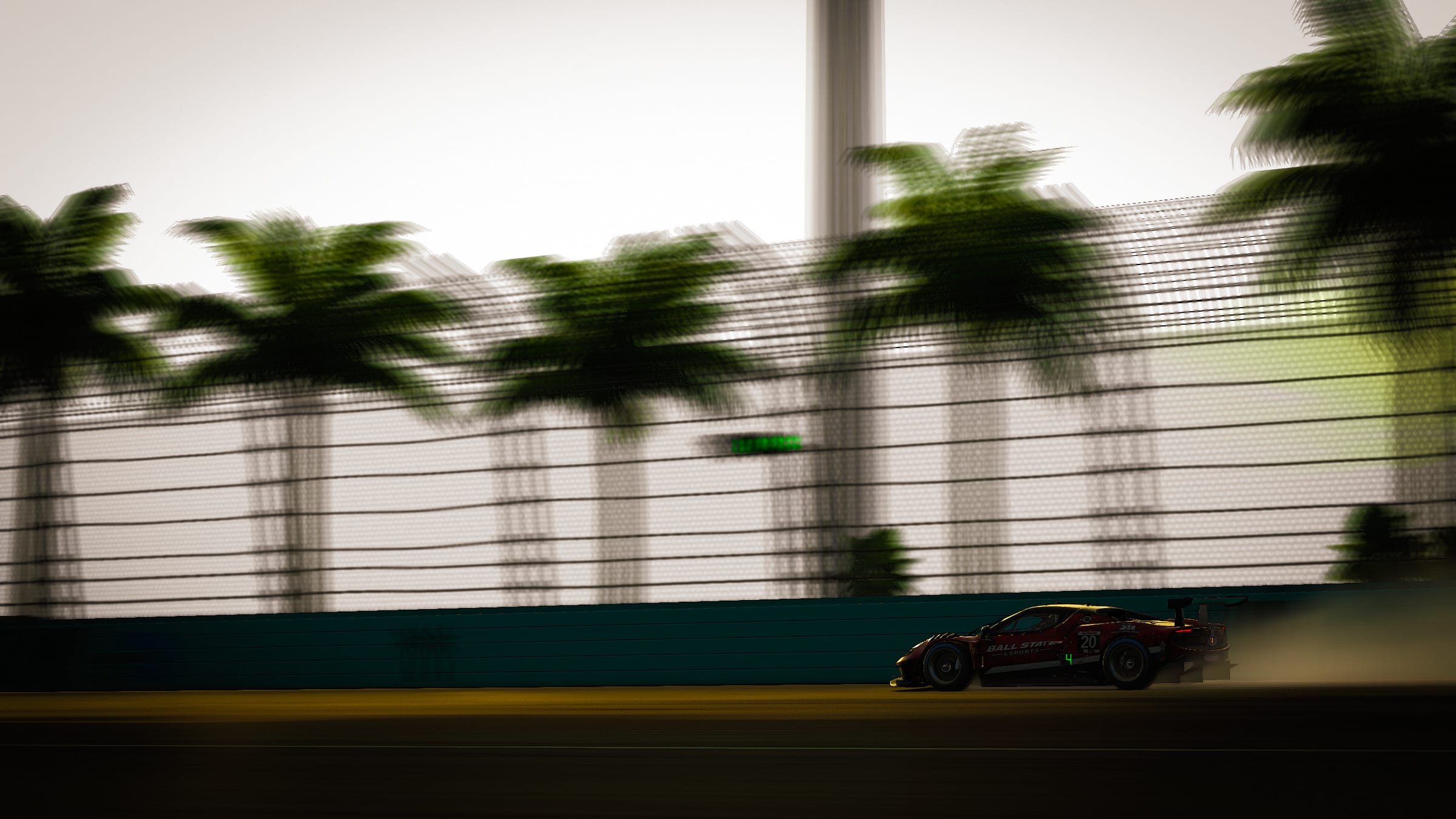 The red #20 Ball State Esports GT3 car passing palm trees and a catch fence, in an iRacing render