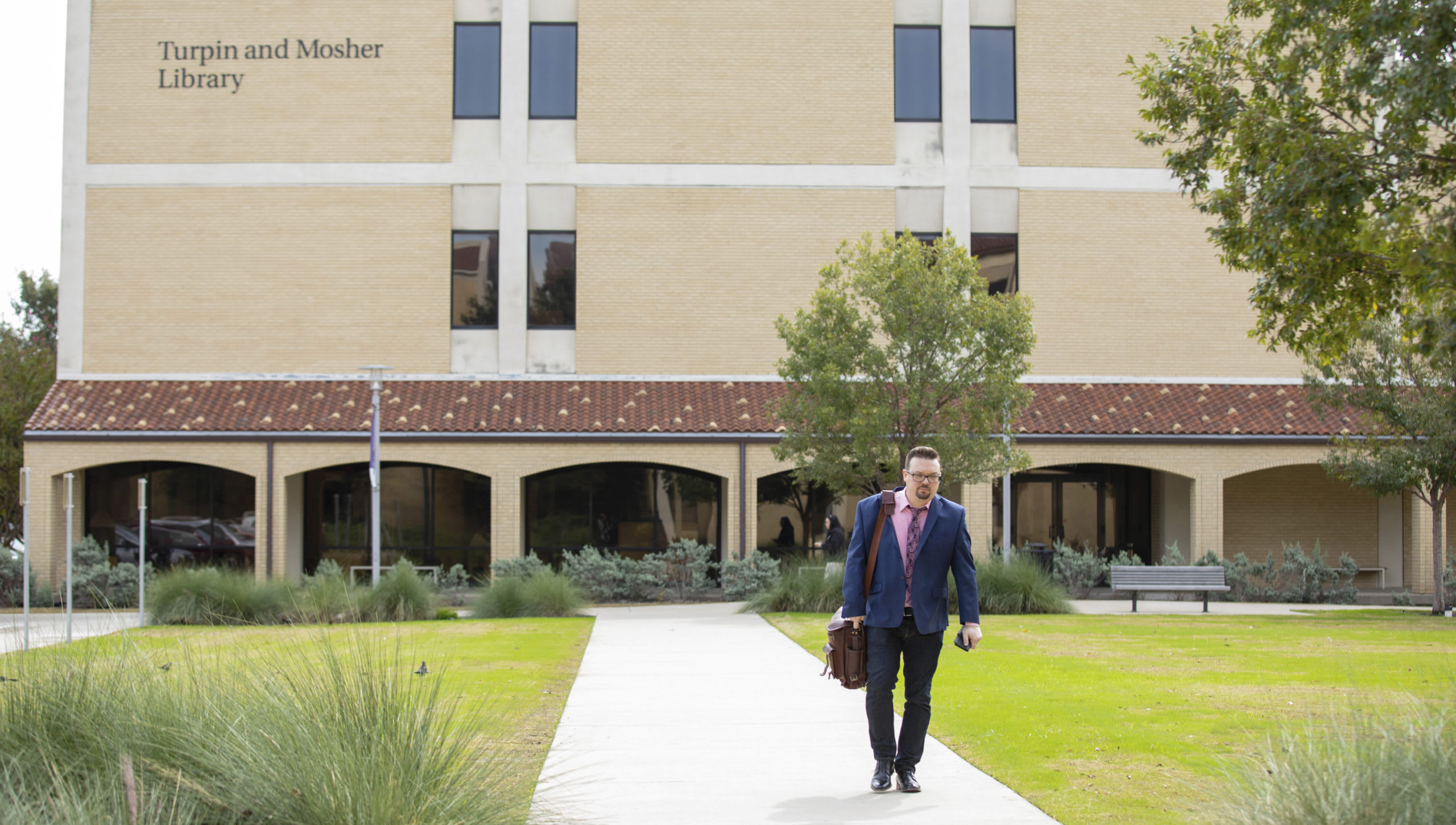 man walking in front of library