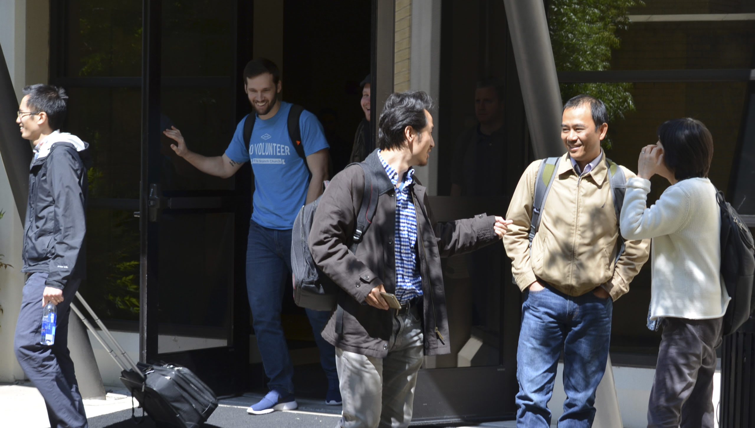 students standing outside in front of a building