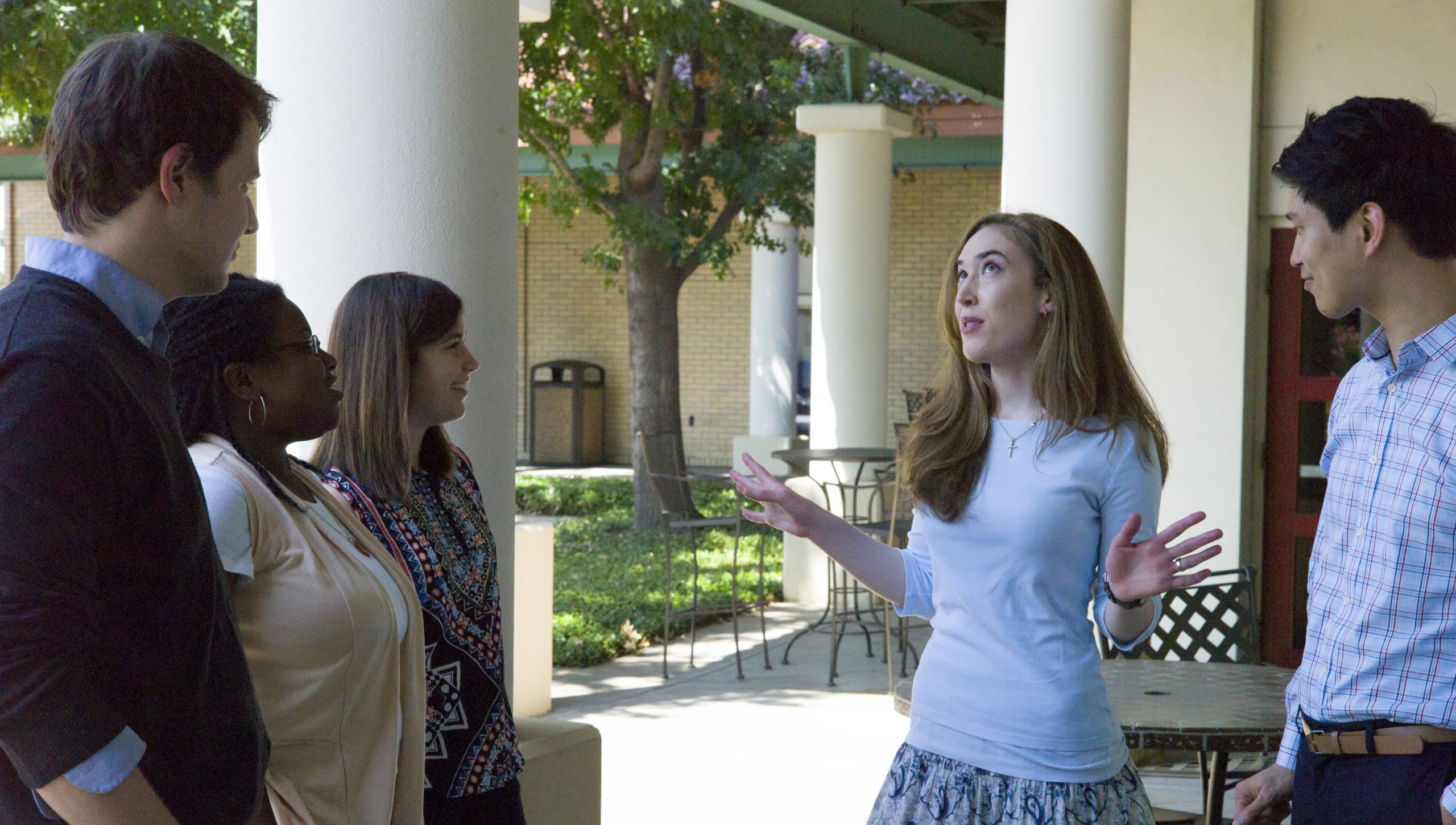 five students talking in front of Mitchel hall