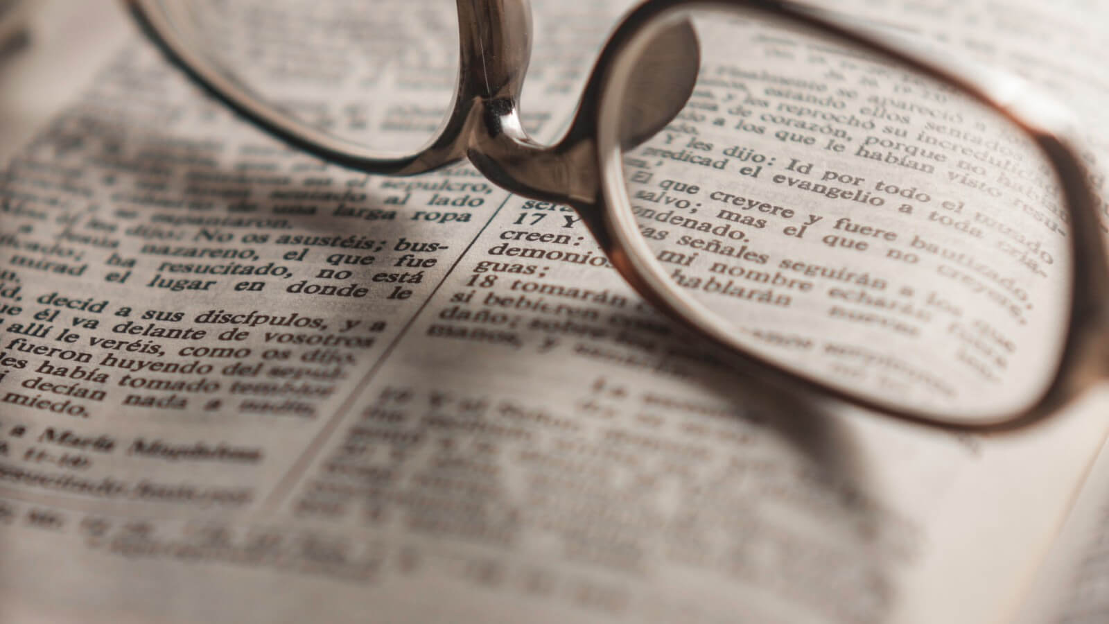 Eyeglasses sitting on top of an open bible in Spanish